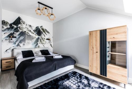 sypialnia z łóżkiem z górskim malowidłem w obiekcie ApartHost Stara Polana Spa w Zakopanem