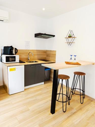 une cuisine avec un comptoir avec des tabourets et une table dans l'établissement Oasis romantique - Sauna, à Peyruis