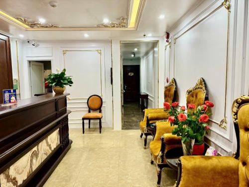a waiting room with yellow chairs and a piano at Bảo Anh Hotel in Hanoi