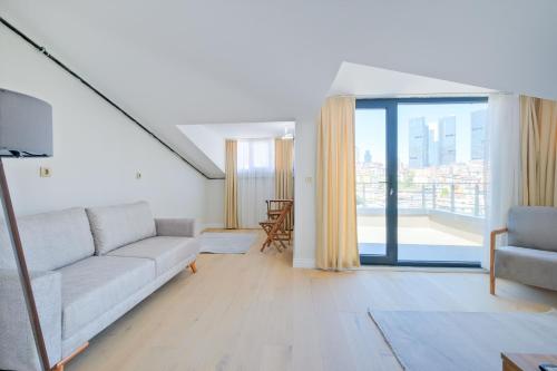 Una sala de estar con un sofá y una ventana grande. en Mayer Skycon Residence in Beşiktaş 2, en Estambul