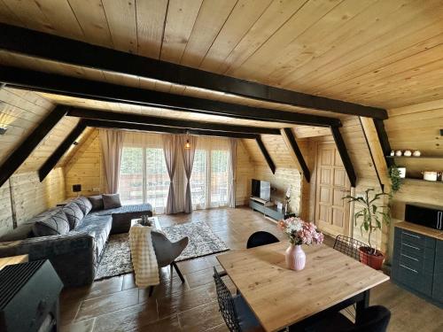 a living room with a couch and a table at Planinska Brvnara Zlatni Bor in Nedići