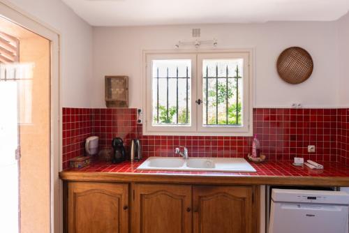 - une cuisine avec un évier et du carrelage rouge dans l'établissement Les 2 Bastides - Famille - Lac de Saint-Cassien, à Bagnols-en-Forêt