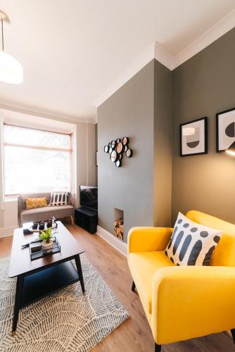 a living room with a yellow couch and a table at Stylish & Well Equipped Modern Home HS2, NEC, Heartlands in Birmingham