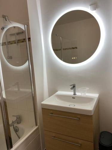 une salle de bain avec un lavabo et un miroir dans l'établissement Maison 2-6 pers avec terrasse,jardin , parking privé, à Saint-Valery-sur-Somme