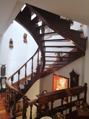a wooden spiral staircase in a home with a stair case at HABITACIONES Casa Paca en Noia in Noya