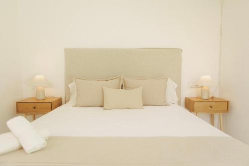 a bedroom with a white bed with two night stands at GAIA Beach House - Exclusive Stay & Free Parking in Conil de la Frontera