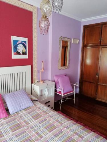 a bedroom with purple walls and a bed and a chair at HABITACIONES Casa Paca en Noia in Noya
