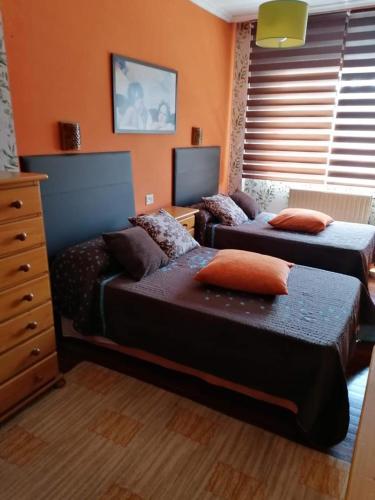 a bedroom with two beds and a dresser at HABITACIONES Casa Paca en Noia in Noya
