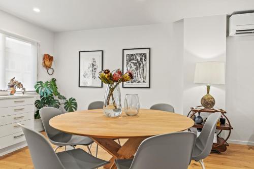 a dining room with a wooden table and chairs at Harakeke Whāre - Christchurch Holiday Homes in Christchurch