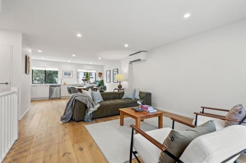 a living room with a couch and a table at Harakeke Whāre - Christchurch Holiday Homes in Christchurch