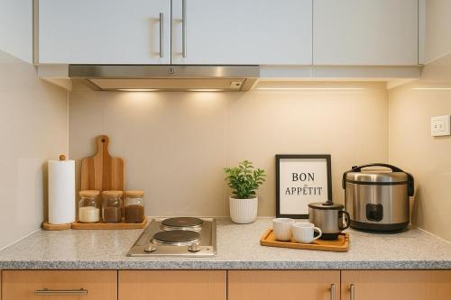 a kitchen counter with a stove and a sign on it at Elegant 1BR near Solaire, Okada, Mall of Asia in Manila