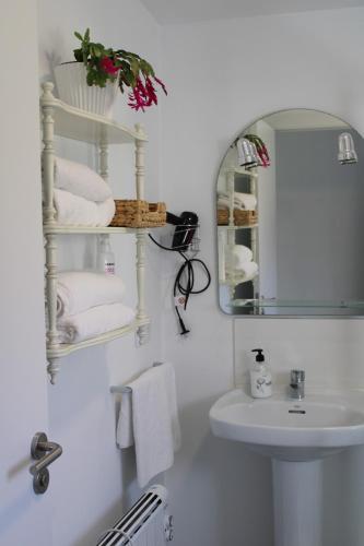 a white bathroom with a sink and a mirror at Relaxing Cabin Next to the River - La Cabaña de Susana in Negreira