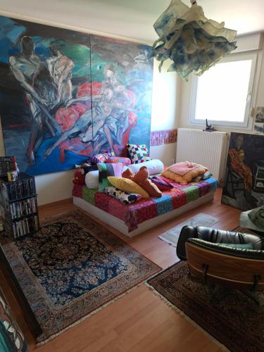 - un salon avec un lit et un tableau mural dans l'établissement MARCHE DE Noel STRASBOURG, à Illkirch-Graffenstaden