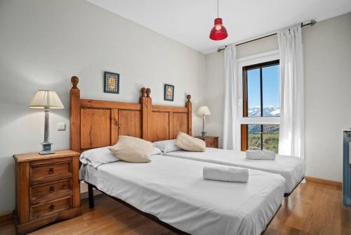 a bedroom with a large bed and a window at El Mirador by Cardi Suites in Formigal