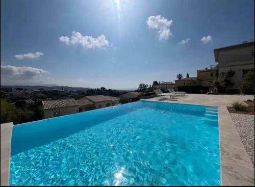 une grande piscine bleue devant une maison dans l'établissement DOMAINE LOU BEL AZUR - Paisible, à Saint-Laurent-du-Var