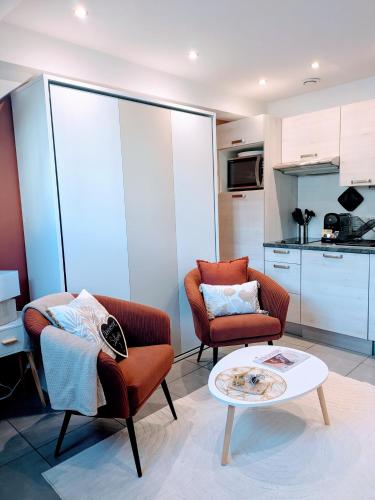 un salon avec deux chaises et une table basse dans l'établissement Le Cocon du Chardon, à Annecy