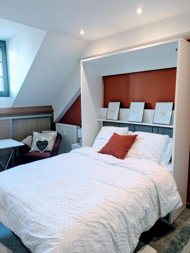une chambre avec un grand lit blanc et une chaise dans l'établissement Le Cocon du Chardon, à Annecy