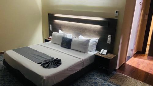 a bedroom with a large bed with a black headboard at Blue sky hotel in Oran