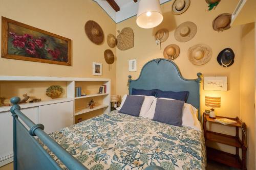 Un dormitorio con una cama con cabecero azul. en la Soffitta, en Campiglia Marittima