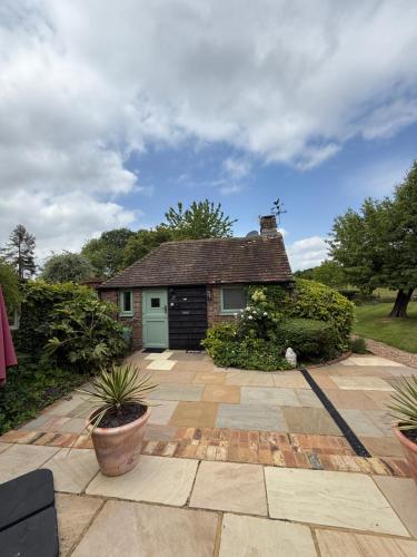 a brick house with a green garage in a yard at Field View in Lower Beeding