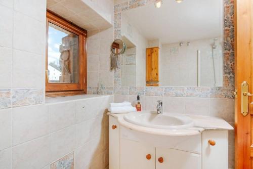 a bathroom with a sink and a mirror at Cantal by Cardi Suites in Sallent de Gállego