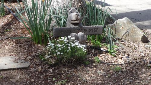 a stone sign in a garden with flowers at Little Valley Inn in Mariposa