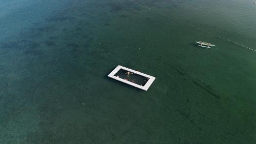 a boat sitting in the middle of the water at Anam Beach Resort in Calatagan