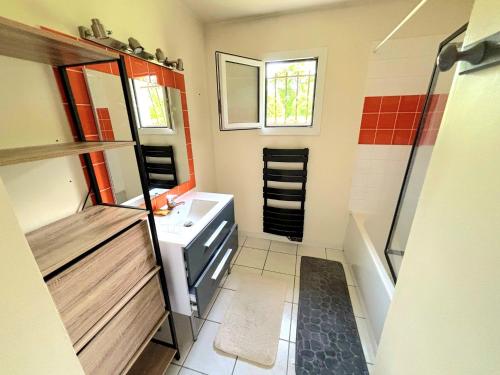 une petite salle de bain avec un lavabo et une douche dans l'établissement Maison vacances et cure thermale, à Vergeroux