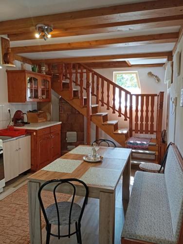 a kitchen with a table and chairs and a staircase at Cseke Kulcsosház in Praid