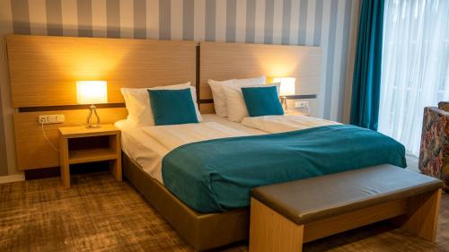 a bedroom with a large bed with blue pillows at Heide Hotel Reinstorf in Reinstorf