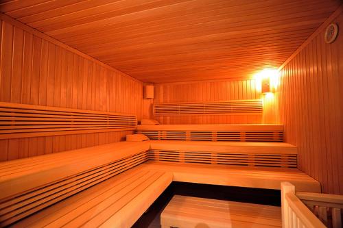 a sauna with wooden seats and a light in it at Heide Hotel Reinstorf in Reinstorf