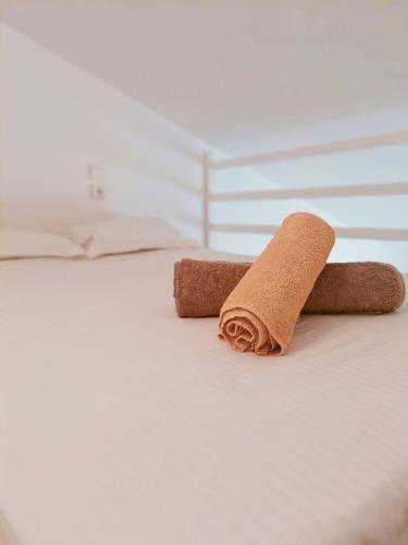 une serviette marron enroulée posée sur un lit dans l'établissement Studio 2 pers avec terrasse centre historique, à La Rochelle