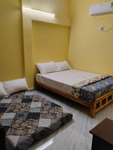 a bedroom with two beds in a room at Kamal Rooms in Tiruvannāmalai