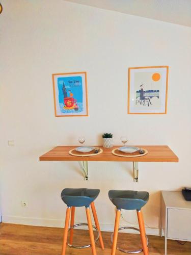 une table avec deux tabourets et deux assiettes dessus dans l'établissement Studio 2 pers avec terrasse centre historique, à La Rochelle