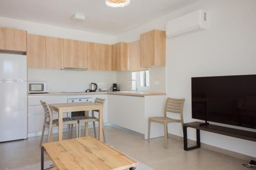 a kitchen with a table and chairs and a television at Amar V in Lechaio