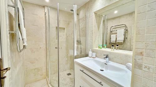 une salle de bain avec un lavabo et une douche en verre dans l'établissement Superb T3 with terrace and sea view, à Théoule-sur-Mer