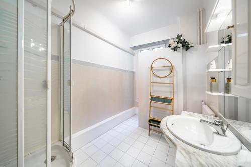 une salle de bain blanche avec un lavabo et une douche dans l'établissement 3 pièces centre-ville Cannes - Croisette - Climatisation séjour, à Cannes