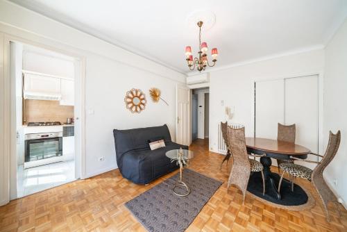 un salon avec une table et un canapé dans l'établissement 3 pièces centre-ville Cannes - Croisette - Climatisation séjour, à Cannes