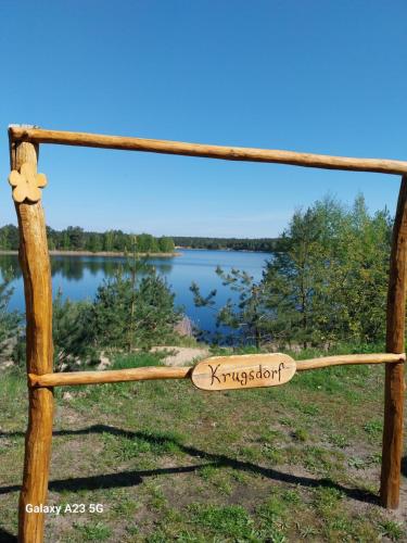 a sign on a wooden fence with a lake in the background at Ferienhaus Seeliebe in Krugsdorf