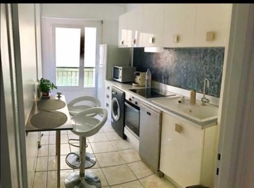 La cuisine est équipée d'un comptoir, d'un évier et d'un lave-vaisselle. dans l'établissement 3 pièces calme 5 mn Port, à Nice