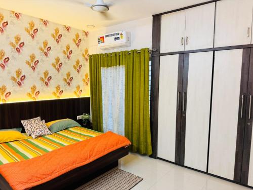 a bedroom with a bed and a green curtain at Gulmohar Villa in Indore