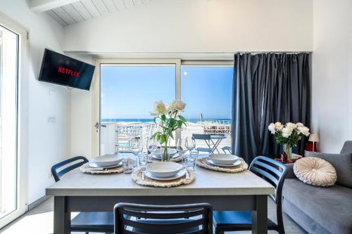 a dining room with a table and a couch at Appartamento Luxury vista mare in Lido di Camaiore
