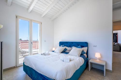 a bedroom with a large blue bed and a balcony at Appartamento Luxury vista mare in Lido di Camaiore