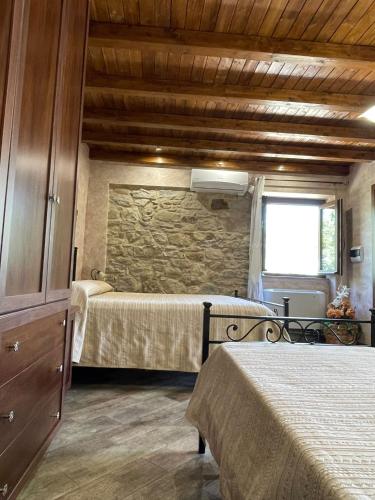 a bedroom with two beds and a stone wall at Villa Russo in Caltanissetta