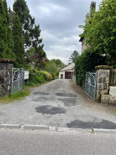 an empty road with a gate and a house at Studio cosy & pratique avec parking privé in Égletons