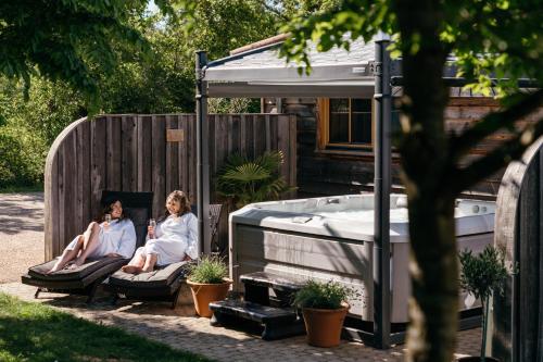 two women sitting on chairs next to a hot tub at Retreat East in Ipswich