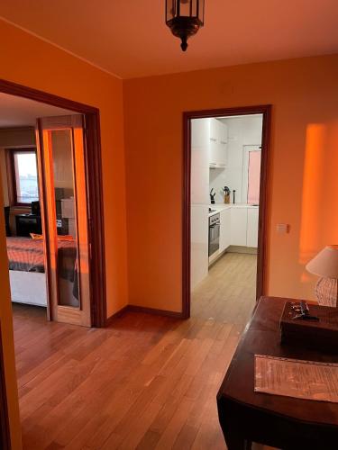 a living room with orange walls and wooden floors at Porto - Sunset flat at the beach - Free parking in Matosinhos