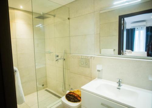 a bathroom with a shower and a toilet and a sink at Accra Luxury Apartments @ The Signature in Accra