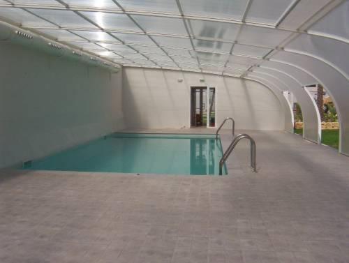 an empty swimming pool with a bench in a building at Gemelos 22-Fincas Benidorm in Benidorm