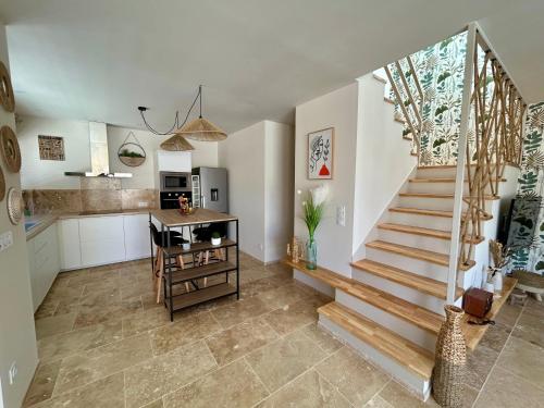 - une cuisine et un escalier dans un salon avec une table dans l'établissement Villa Balaruc-Les-Bains, à Balaruc-les-Bains